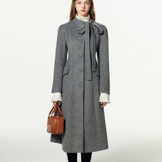 A classic wool coat that pays homage to 1950s movie actresses. It is characterized by large rounded buttons, and the neck is decorated with a long ribbon. A silhouette that flares out toward the hem while showing off the curvaceous waistline. 
 
 
 Size 
 
 S size 
 
 Length: 115.5cm 
 Shoulder width: 54cm 
 Bust: 90cm 
 Waist: 79cm 
 Sleeve length: 54cm 
 
 M size 
 
 Length: 116.5cm 
 Shoulder width: 55cm 
 Bust: 94cm 
 Waist: 83cm 
 Sleeve length: 55cm 
 
 L size 
 
 Length: 117.5cm 
 Shoulde Elegant Wool Coat With Button Cuffs For Office, Elegant Wool Coat With Covered Buttons For Work, Chic Fitted Wool Coat With Button Cuffs, Elegant Winter Wool Coat With Button Cuffs, Elegant Fitted Wool Coat With Button Cuffs, Elegant Wool Coat With Button Cuffs For Fall, Elegant Wool Coat With Buttons, Chic Winter Outerwear With Bow, Long Wool Coat