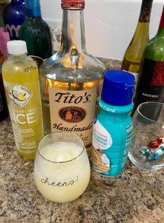 bottles and glasses are sitting on the counter next to each other with drinks in them