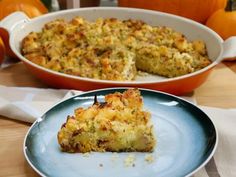 a slice of quiche on a blue plate next to an orange casserole dish