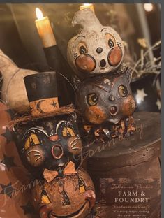 three pumpkins with faces on them sitting next to each other in front of a candle