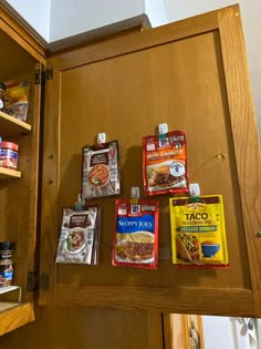 several packets of food are hanging on the wall in front of some shelves with other items