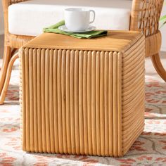 a coffee table with a cup on top of it next to a wicker chair