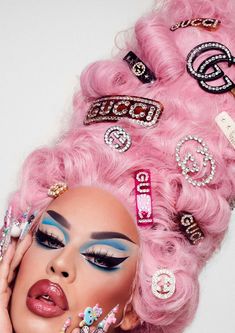 a woman with pink hair and lots of jewels on her face is posing for the camera