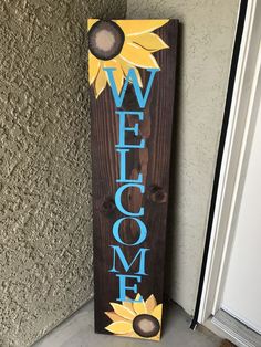 a wooden sign that says welcome with sunflowers painted on the front and side