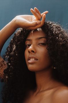 a close up of a person touching their hair