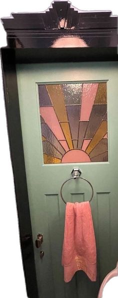 a green door with a pink towel hanging on it