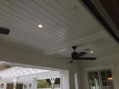 a ceiling fan on the outside of a home's front porch with white siding