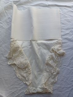 Vintage Frederick's of Hollywood panty, girdle, tummy hugger shapewear. Made of 85% nylon and 15% spandex, in an off-white cream color. The top is made of a firm and wide elastic band. The band is 10.5 inches across un-stretched (21 inches circumference) to 14 inches across (28 inches circumference) fully stretched. The gusset is unlined. The legs are lined with lace. The entire piece measured from the top to the crotch is 15.5 inches, with an extra 2-inch stretch. I'm guessing this will fit a modern size Medium. Please keep in mind, this is shapewear, so it is meant to be fitted and not loose. In good condition. I did not see any issues. Fitted Full Coverage Bottoms For Daywear, Elegant Fitted Shapewear With Lace Trim, Fitted Full Coverage Shapewear With Lace Trim, Fitted White Underbust Shapewear, Fitted Lace Trim Shapewear, Daywear Bottoms With Built-in Bra And Stretch, Elegant Shaping Bottoms For Daywear, Elegant Underbust Stretch Shapewear, Elegant Fitted Shapewear With Boning