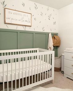 a white crib in a green and white nursery