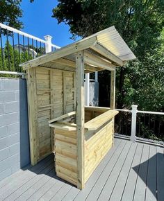 a small wooden bar on a deck with trees in the background