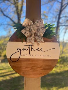 a wooden sign that says gather and be grateful with a bow on it's side