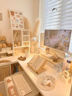 a desk with a computer monitor, keyboard and mouse on it in front of a window