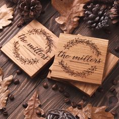 two personalized wooden coasters with the words, the millers and an oak wreath surrounded by autumn leaves