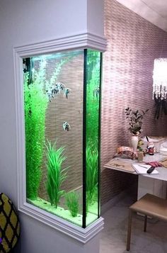 a fish tank in the corner of a room with plants and other things inside it