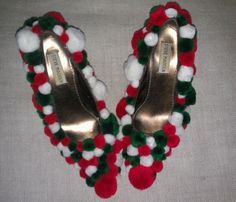 pair of high heeled shoes decorated with pom - poms