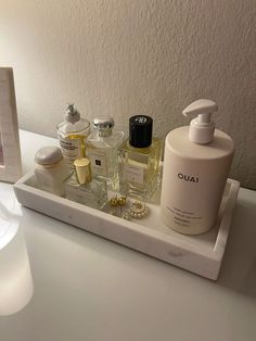 an assortment of personal care products displayed on a white tray next to a framed photograph