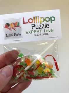 a hand holding a bag of gummy bears in it's left side, with the label for lollipop puzzle expert level