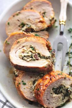 meatloaf stuffed with spinach and cheese on a white plate next to a fork