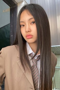 a woman with long hair wearing a suit and tie