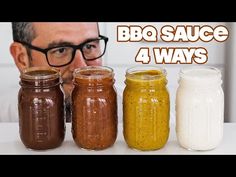 three jars with different types of sauces in them and a man looking at the camera