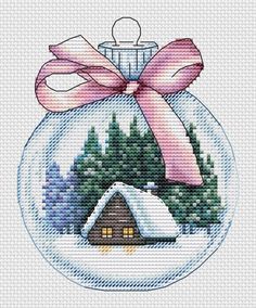 a cross stitch christmas ornament with a pink bow