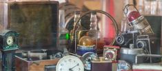 an assortment of antique items are displayed in a shop window, including a clock and other antiques