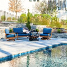 a pool with some chairs and a fire pit