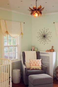 a baby's room with a crib, rocking chair and large sunburst