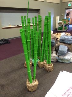 there are many green plants made out of rocks and sticks in the middle of an office lobby