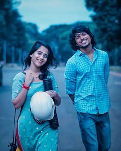 a man and woman standing next to each other on the street with a ball in their hand