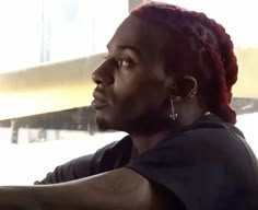 a man with red dreadlocks sitting in a car and looking out the window