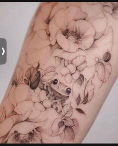 a woman's arm with flowers and a frog tattoo on the left side of her arm