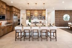 a large kitchen with marble counter tops and wooden cabinets, along with an island in the middle