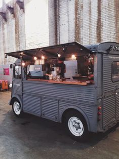 a food truck parked in front of a brick wall with lights on it's roof