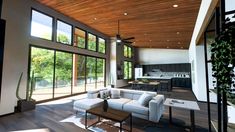 a living room filled with furniture and windows next to a wooden ceiling covered in wood planks