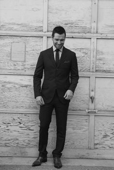 a man in a suit standing next to a garage door