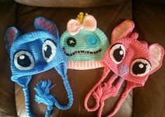 three crocheted hats sitting on top of a couch