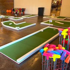 an indoor miniature golf course with carts and tees