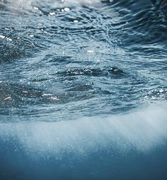 the water is very clear and blue with little bubbles on it's surface,