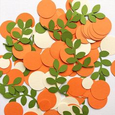 a pile of orange and white paper with green leaves on it's sides, surrounded by circles