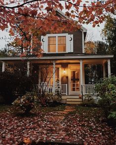 a house that is in the fall with leaves on the ground and trees around it