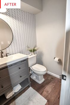 a white toilet sitting in a bathroom next to a sink and wooden floored floors