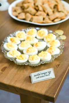 an assortment of baked goods displayed on a wooden table with plates and bowls in the background