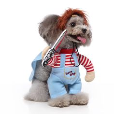 a small dog wearing overalls and holding a pair of scissors