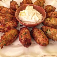 a plate topped with fried food next to a bowl of dip