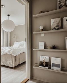 an open door leading to a bedroom with a bed and bookshelves on the wall