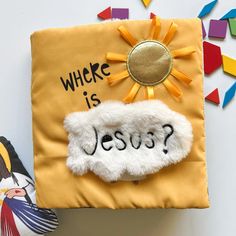 a yellow pillow with the words where is jesus written on it and a sun decoration