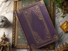 a purple book sitting on top of a table next to other decorations and decor items