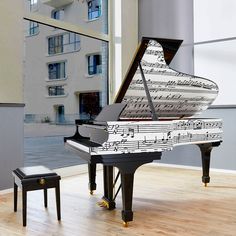 a piano with sheet music on it in front of a large window and two stools