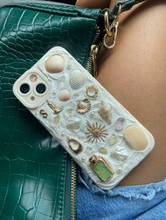 a cell phone case with shells and seashells attached to the back of a woman's body